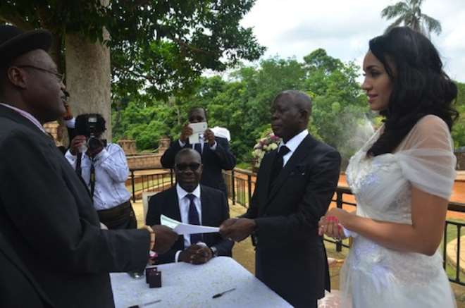 The officiating minister hands marriage certificate to Governor Oshiomhole