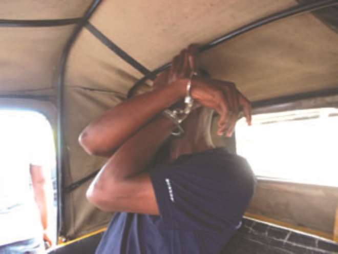 Shittu, hiding his face after he was arrested and handcuffed for slapping a Chief Magistrate. PHOTOS: YUSUF MUHAMMED